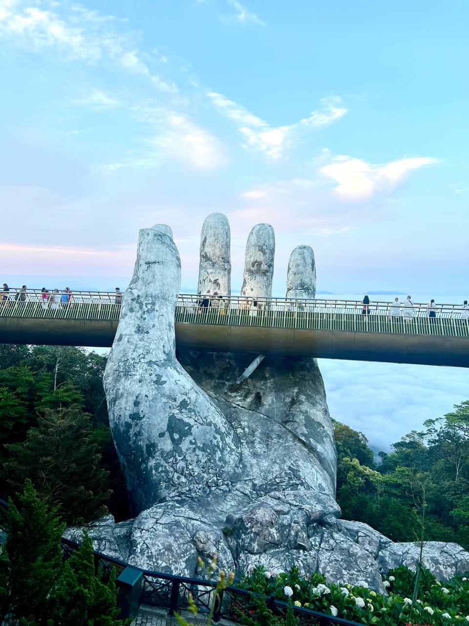 The Golden Bridge — giant stone hands holding up the walkway above the clouds